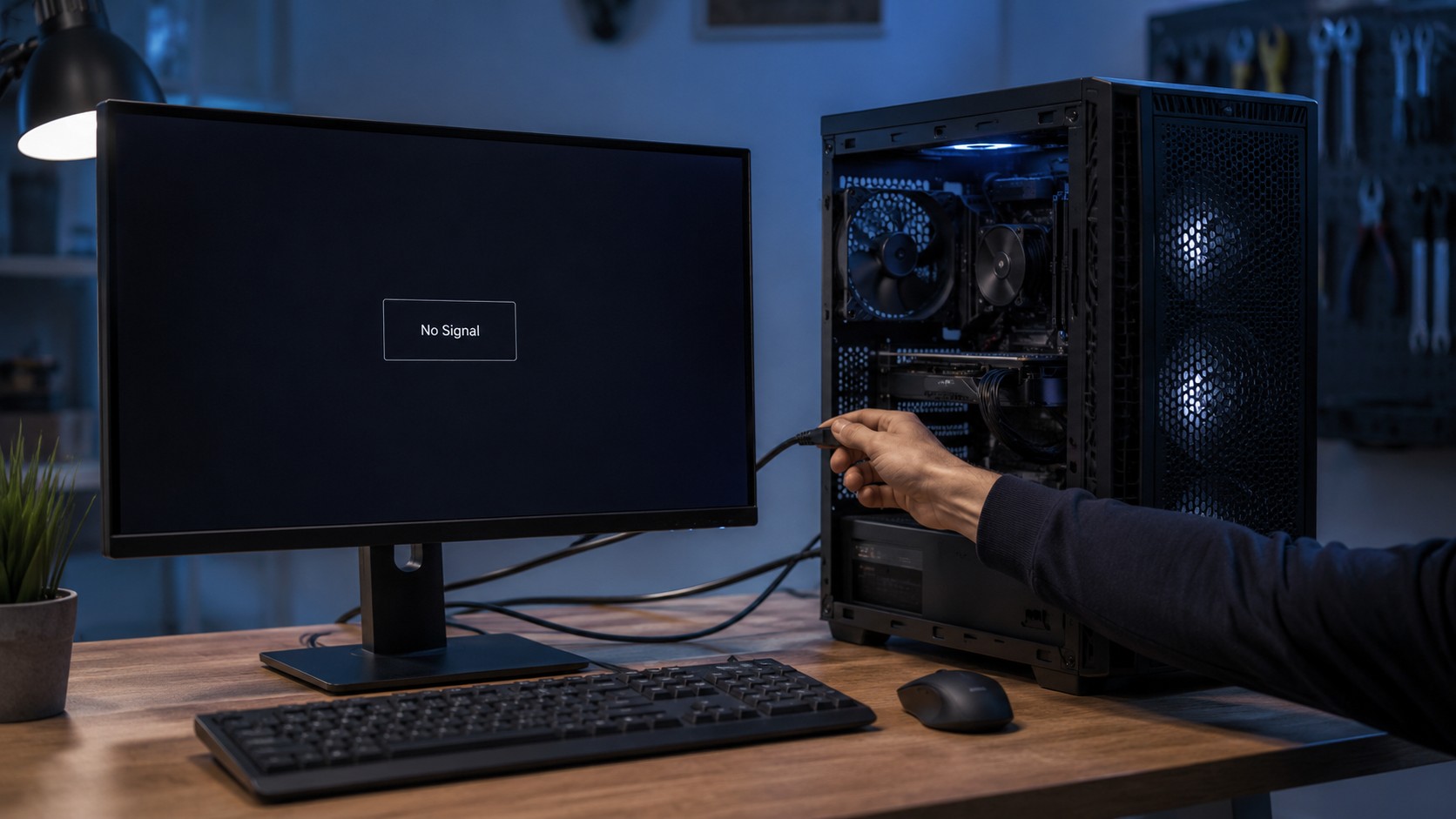 Desktop computer powered on beside a monitor showing no signal during troubleshooting